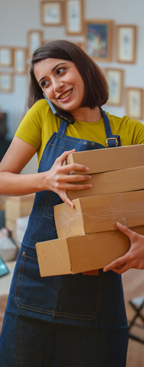 Woman wearing apron on mobile holding boxes